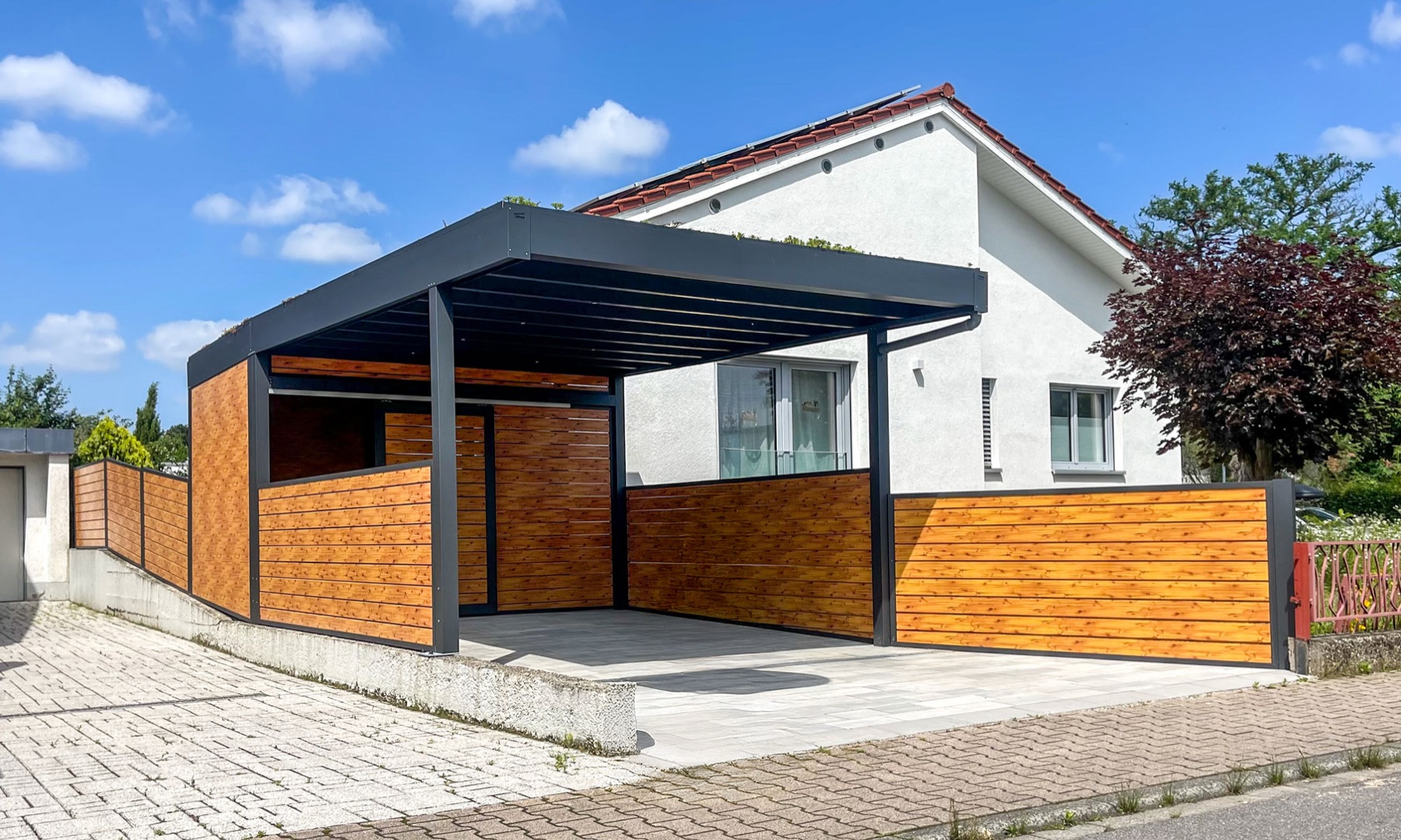 Flachdach-Carport anthrazit mit Holzoptik-Seitenwänden und Dachbegrünung