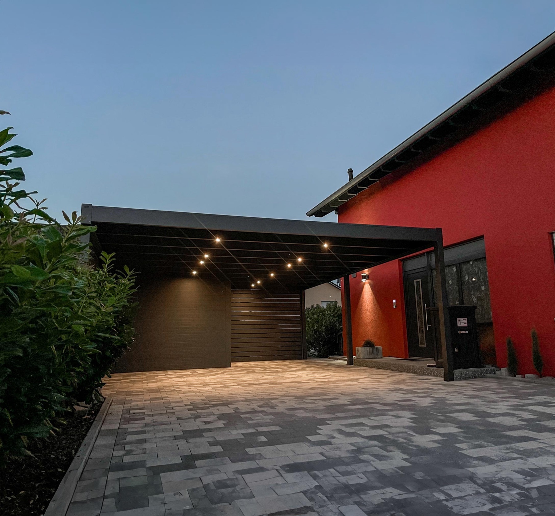 Carport mit integrierter LED-Beleuchtung in der Abenddämmerung