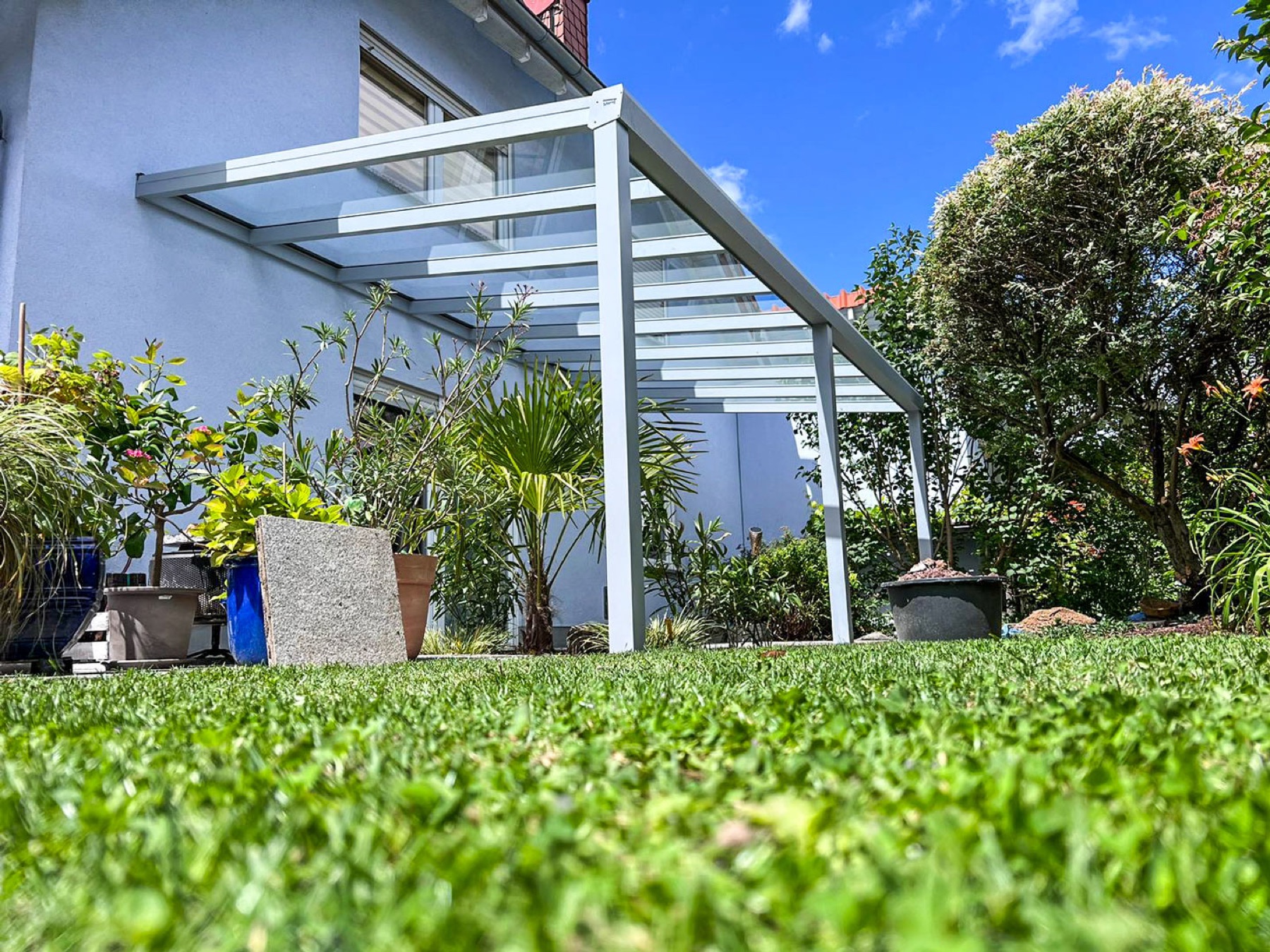 Glasdach-Terrasse mit Blick in den begrünten Garten