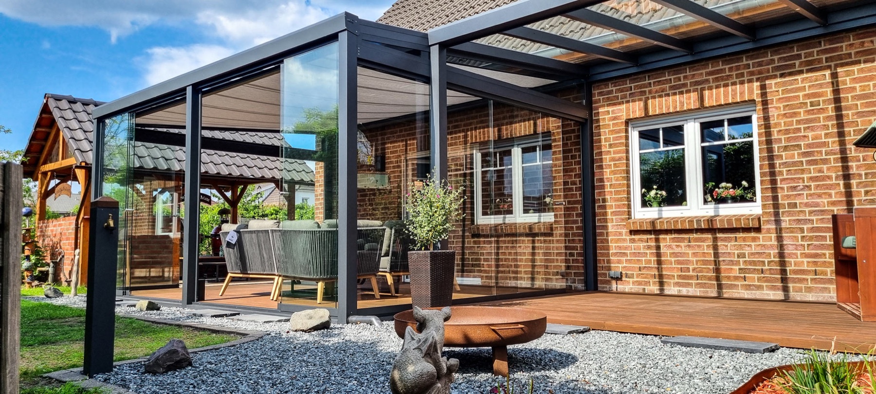 Anthrazit-Terrassenüberdachung mit Glas-Schiebewänden zum Sommergarten